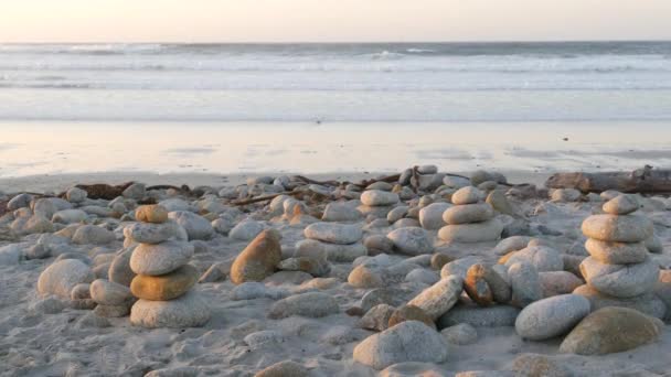 岩石平衡的卵石海滩 蒙特雷17英里开车 加州海岸 稳定的金字塔堆满了圆形的石头 海浪在日落的时候冲刷着 宁静的和谐 平静的禅定 — 图库视频影像