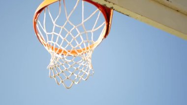 Basketbol sahası, turuncu halka, beyaz ağ ve dışarıda basket maçı için sedye. Sokak arasında eğlence amaçlı spor ekipmanları, ABD caddesinde oyun alanı. Mavi gökyüzü arkaplanı.