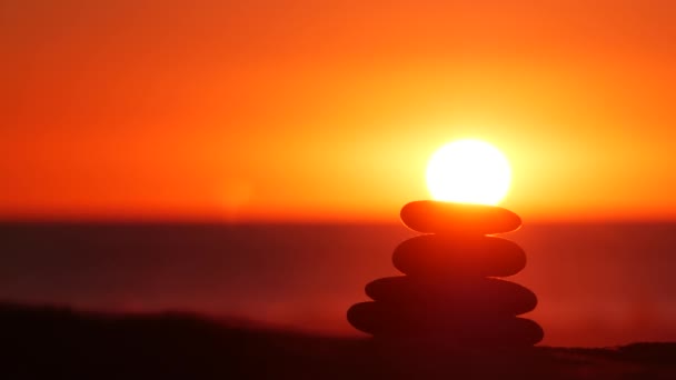 日没の空のスタック 岩の太陽の光で 海の水の波のバランス ピラミッドの山にある石 禅の瞑想とバランスの調和 シームレスループされたシネマグラフ — ストック動画