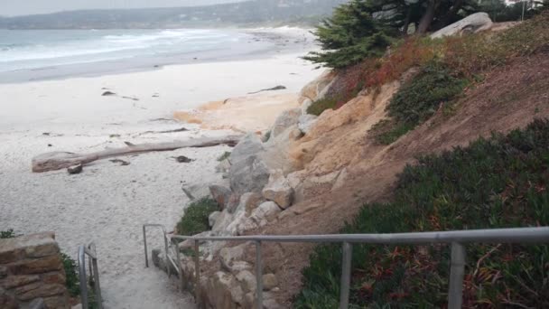 カーメルの海の砂浜 モントレーベイ自然 カリフォルニア州海岸 海岸に大きな泡の海の水の波がクラッシュします 休暇ウォーターフロントのビーチフロントリゾート 霧の天気 階段または階段 — ストック動画