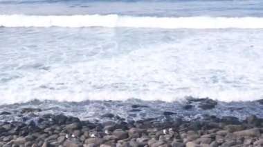 Okyanus dalgaları sahile çarpıyor, yukarıdan deniz suyu yüzeyi, uçurum ya da kayalık, La Jolla sahili, California USA. Pasifik kıyısındaki tatil beldesi. Deniz manzarası doğal arka plan, çakıl taşları veya taşlar