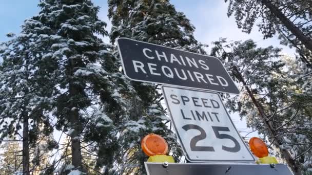チェーンまたはスノータイヤは 交通標識 山岳冬の高速道路 ヨセミテ雪の森 カリフォルニア州アメリカを必要とした 氷の道路の注意や警告 輸送のための降雪中の安全性 森の中の制限速度 — ストック動画