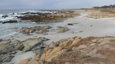Kayalık okyanus kıyıları, kayalara vuran deniz dalgaları, 17 mil sürüş, Monterey, California USA. Point Lobos, Big Sur, Pebble plajı yakınlarındaki doğa. Hava bulutlu. Yaya yolu, yürüyüş yolu veya patika yolu