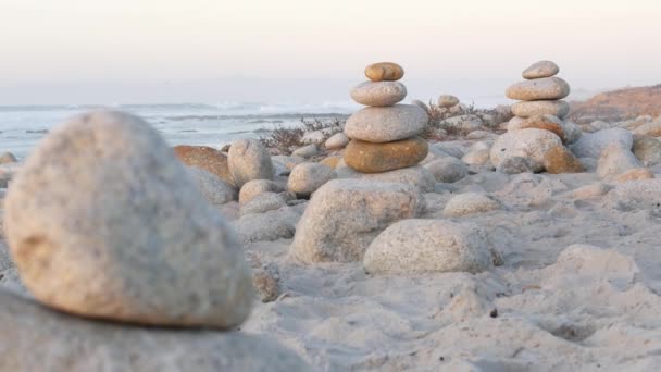 ペブルビーチ モントレー17マイルドライブ カリフォルニア州海岸 米国の岩のバランス ラウンド石の安定したピラミッドスタック 海の海の水の波が日没にクラッシュします 静けさの調和 穏やかな禅の瞑想 — ストック動画
