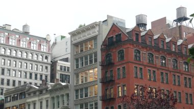 New York 5. Cadde, Manhattan şehir merkezi bina köşe mimarisi. Şehir dışındaki konutlar. ABD 'de gayrimenkul. Tipik kırmızı tuğla cephesi. Çatıdaki su kulesi, çatıdaki tank.