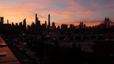 New York City Manhattan siluet şehri. Queens 'teki çatı, şehir merkezindeki binalar, Queensboro Köprüsü. Long Island 'ın çatısından gün batımı pembe gökyüzü. Gökdelenlerin silueti, yüksek binaların mimarisi, NYC