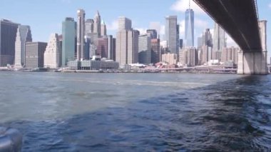 New York City, Manhattan şehir merkezi feribottan ufuk çizgisi. Brooklyn Köprüsü. Feribottan Dünya Ticaret Merkezi gökdelenine. Doğu nehri kıyısı manzarası, nehir kenarındaki binalar, ABD.
