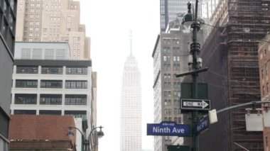 New York Şehri kavşağı, yol kavşağı tabelası. Empire State Binası, Midtown Bölgesi, Batı 34, New York, ABD. Yükselen gökdelen mimarisi, 9. cadde metin yol işareti.