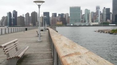 New York şehri kıyısı silueti, Manhattan şehir merkezi binaları, nehir kıyısındaki gökdelenler, doğu nehri suyu. Liman kenti manzarası, Gantry Plaza iskelesi, Long Island, Queens. Birleşik Devletler mimarisi.