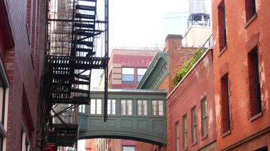 New York City Staple Caddesi, Skybridge. Antika endüstriyel mimari, kırmızı tuğla bina. Amerikan eski fıçısı Manhattan 'daki gökyüzü köprüsünü yükseltti. Yangın merdiveni. Su kulesi tankı.