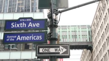 New York City kavşağı, sokak kavşağı tabelası. 6. Cadde, Americas Bulvarı köşe işareti, Midtown Bölgesi. Herald Meydanı 'ndaki Gimbels Köprüsü, Art deco bakır Skybridge. Tek yönlü ok.