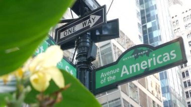 New York City kavşağı, sokak kavşağı yeşil yol tabelası. 6. Cadde, Amerika Bulvarı, Midtown İş Bölgesi, New York, Bryant Park. Yükselen gökdelen mimarisi, tek yönlü metin yol işareti.