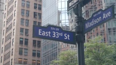 New York City kavşağı, Manhattan köşesi, Madison Bulvarı, sokak kavşağı tabelası. Midtown merkez bölgesi mimarisi, Birleşik Devletler. Tek yönlü ok işareti, gökdelenler. Düşük açı.