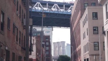 New York City Manhattan Köprüsü, Dumbo, Brooklyn Köprüsü. Brooklyn 'deki Plymouth caddesinde endüstriyel kırmızı tuğla binalar. Yangın merdivenli klasik NYC mimarisi. İki köprü turist manzaralı.