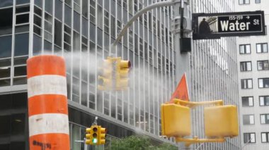 New York Su Sokağı 'nda buhar sızıntısı, turuncu buhar borusu yığını. Pipo dumanı. Con Edisons Buhar Operasyonları Sistemi, Manhattan şehir merkezi finans bölgesi mimarisi. Trafik ışığı