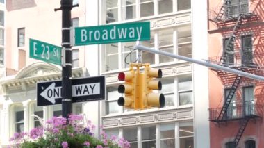 Broadway sokak tabelası, Manhattan şehir merkezi mimarisi, New York köşesi. Sarı trafik ışığı. Madison Square Park yakınlarındaki Flatiron bölgesinde. 23. Cadde, Bway ve 5. Cadde 'nin kesiştiği yerde. Tek yön