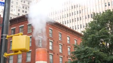 Buhar sızıntısı, New York Su Sokağı, turuncu buhar boruları. Pipo dumanı. Con Edisons Buhar Operasyonları Sistemi, Manhattan şehir merkezi finans bölgesi mimarisi. Kırmızı tuğla ev