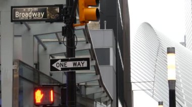 Broadway caddesi tabelası, Manhattan şehir merkezi finans bölgesi mimarisi. New York City, Fulton caddesi köşe tabelası. Dünya Ticaret Merkezi yakınlarında sarı trafik ışığı. Metro girişi. Tek yönlü ok