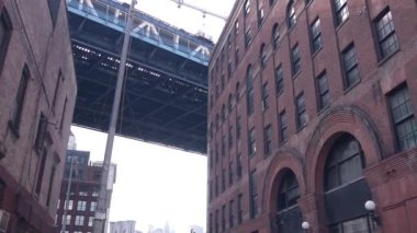 Dumbo, Brooklyn 'deki New York City Manhattan Köprüsü. Water Caddesi Kemer Yolu 'nun yanındaki Plymouth Caddesi' ndeki kırmızı tuğladan bina. Klasik NYC endüstriyel mimarisi altında. Amerika Birleşik Devletleri 'nin altında turistik bölge.