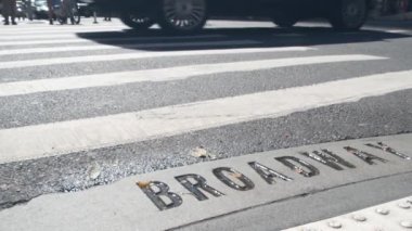 Broadway sokak tabelası, yaya zebra kavşağındaki insanlar. New York City Manhattan kavşağı. Yaya geçidinde asfalt, kavşaktaki gölgeler. Trafik levhası, Birleşik Devletler