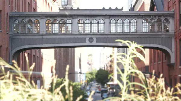 stock image New York City street, Chelsea Market skybridge. Retro industrial architecture, red brick building. American old historic elevated sky bridge Manhattan landmark, USA. Meatpacking district, High Line.