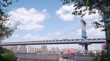 New York, Amerika Birleşik Devletleri - 30 Ağustos 2023: Manhattan Köprüsü 'nden Brooklyn Dumbo' ya. Time Out Market 'in çatısındaki bankta, Amerika Birleşik Devletleri' nin simgesel seyahat hedefi. New York 'un çatı katındaki insanlar.