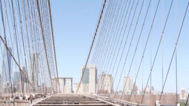New York, ABD - 3 Eylül 2023: Brooklyn Köprüsü 'nden Manhattan şehir merkezi silueti, kablolar ve mavi gökyüzü. Finansal bölge şehir manzarası. Dünya Ticaret Merkezi, ABD Seyahat Merkezi.