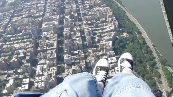 stock image New York City doors off helicopter flight, heli flying over Manhattan West Side houses, United States. Feet in sneakers, legs in shoes selfie pov. Extreme tourist adventure, travel USA. Camera shaking