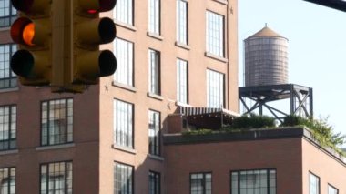 New York caddesi kavşağı, sarı trafik ışığı, ulaşım yolu kavşağı, Birleşik Devletler. Konut mimarisi. Çatı su kulesi, tank. Kırmızı kahverengi tuğla ev. Manhattan, NYC.