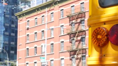 New York Manhattan caddesinde sarı okul otobüsü, şehir yolunda okul otobüsü kamyonu. Çocuk eğitim ve ulaşım, ABD. Amerikan okul servisi, 10 Avenue Chelsea kırmızı tuğlalı ev, Amerika Birleşik Devletleri.