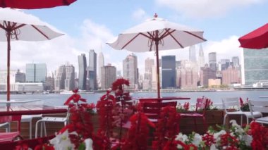 New York şehri kıyısı silueti, Manhattan şehir merkezi binaları, nehir kıyısındaki gökdelenler, doğu nehri kıyısındaki kafe şemsiyeleri. Hunters Point, Long Island, Queens, ABD 'den liman kenti manzarası.