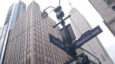 New York Şehri kavşağı, yol kavşağı tabelası. Empire State Binası, Midtown Bölgesi, Madison Bulvarı, 34, NYC, ABD. Yükselen gökdelen mimarisi, köşe metin yol işareti.