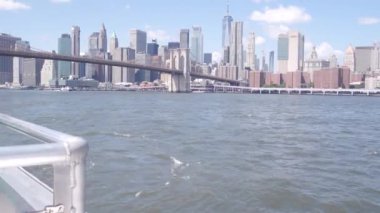 New York City, Manhattan şehir merkezi feribottan ufuk çizgisi. Brooklyn Köprüsü. Feribottan Dünya Ticaret Merkezi gökdelenine. Doğu nehri kıyısı manzarası, nehir kenarındaki binalar, ABD.