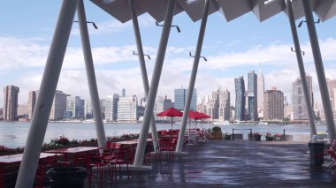 New York şehri kıyısı silueti, Manhattan şehir merkezi binaları, nehir kıyısındaki gökdelenler, doğu nehri suyu. Waterside şehir manzarası, Hunters Point rıhtım kolonları, Long Island, Queens. Birleşik Devletler.