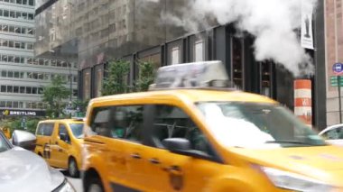 New York, ABD - 11 Eylül 2023 Manhattan Midtown Caddesi, 5. Cadde. Amerikan şehir trafiği, ABD 'de sarı taksi. Sıcak baca, turuncu buhar borusu. Rolex mağazası.