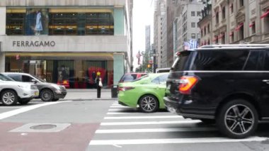 New York, Birleşik Devletler - 11 Eylül 2023 Manhattan Midtown Caddesi, Beşinci Cadde. Amerikan şehir trafiği. Sarı ve yeşil boro taksi. - İnsanlar. Butik moda lüks mağazaları, Amerikan alışveriş merkezleri.