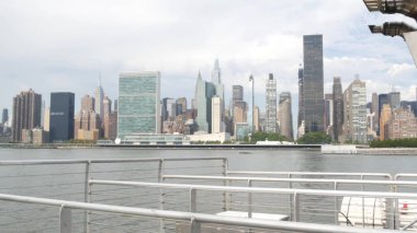 Feribottan New York City silueti. Manhattan şehir merkezinde, feribottan yükselen gökdelenler. Doğu nehri kıyısı manzarası, nehir kenarı mimarisi, ABD. Empire State, Chrysler Binası.