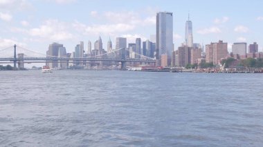 Feribot ile New York City şehir merkezinin silueti. Manhattan ve Brooklyn köprüsü. Feribottan Dünya Ticaret Merkezi gökdelenine. Doğu nehri kıyısı manzarası, nehir kenarındaki binalar, ABD.