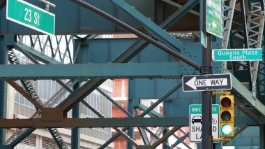 New York metrosu, metropol köprüsü, caddenin üstündeki metro yolu. Demiryolu taşımacılığı. Demiryolu hattı. Queens toplu taşımacılığı. Long Island City, Birleşik Devletler. Sarı trafik ışığı