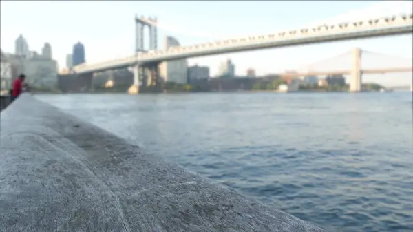 stock image New York City Manhattan Bridge to Dumbo, Brooklyn Bridge. Defocused waterfront skyline cityscape, fisherman on riverfront Pier 35, USA. East river view, people and morning sunset, man fishing by water