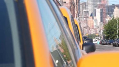 New York 'ta. Queens caddesindeki sarı taksiler. Long Island, LIC 'de bir sürü taksi var. Madalyon taksi ve Manhattan şehir merkezi şehir merkezi silueti. Yüksek binalı mimari.