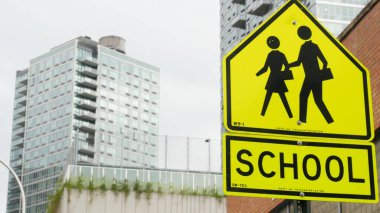 Okul bölgesi sarı yol işareti, yaya geçidi. New York 'ta çocuklar güvende. Ulaştırma ve eğitim sembolü, ABD. Queens, Long Island, Hunters Point 'te trafik işaretleri.