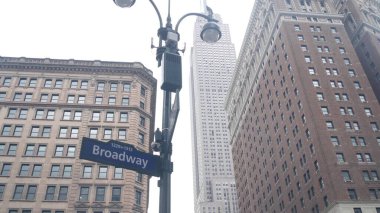 New York City crossroad, street intersection road sign on post. Empire State building, Midtown district, Broadway, 34, NYC, United States. Highrise skyscraper architecture, Bway corner text roadsign. clipart