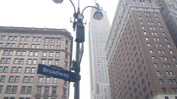 stock image New York City crossroad, street intersection road sign on post. Empire State building, Midtown district, Broadway, 34, NYC, United States. Highrise skyscraper architecture, Bway corner text roadsign.