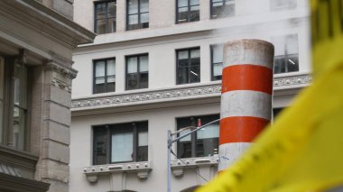 New York caddesinde buhar sızıntısı, turuncu buhar borusu yığını. Pipo dumanı. Con Edisons Buhar Operasyonları Sistemi, 5. Cadde, Manhattan Midtown. Sarı uyarı bandını geçmeyin.