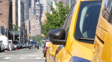New York 'ta. Queens caddesindeki sarı taksiler. Long Island, LIC 'de bir sürü taksi var. Madalyon taksi ve Manhattan şehir merkezi şehir merkezi silueti. Yüksek binalı mimari.