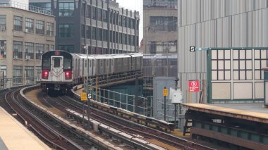 New York metro istasyonu. Metropolitan platformunda metro treni, Birleşik Devletler toplu taşımacılığı. Queens 'teki Court Square demiryolu hattında yükseltilmiş. New York yolcusu tren yolu trafiği, Long Island City