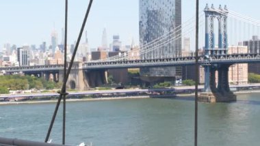 New York, ABD - 3 Eylül 2023 Brooklyn Köprüsü manzaralı Manhattan Köprüsü. Şehir merkezindeki Empire State binası. New York Skyline şehir manzarası. Doğu Nehri suyunun üzerindeki ikonik mimari kablolardan..