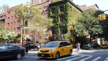 New York City, ABD, 6 Eylül 2023 Manhattan şehir merkezi Irving sokak köşesi, kavşak, Gramercy, ABD. İnsanlar yayalar. Sarı taksi. Sarmaşık yapraklarıyla kaplı kırmızı tuğladan ev