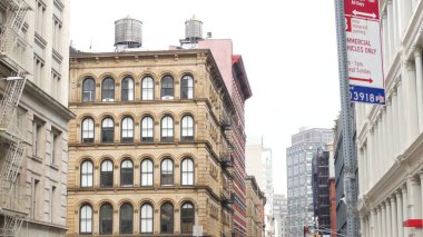 Broadway caddesi yakınlarındaki New York City Manhattan Soho moda bölgesi. Amerikan şehir binası cephesi, eski klasik Amerikan mimarisi. NYC 'de ikamet eden gayrimenkul. Çatıda su deposu var.